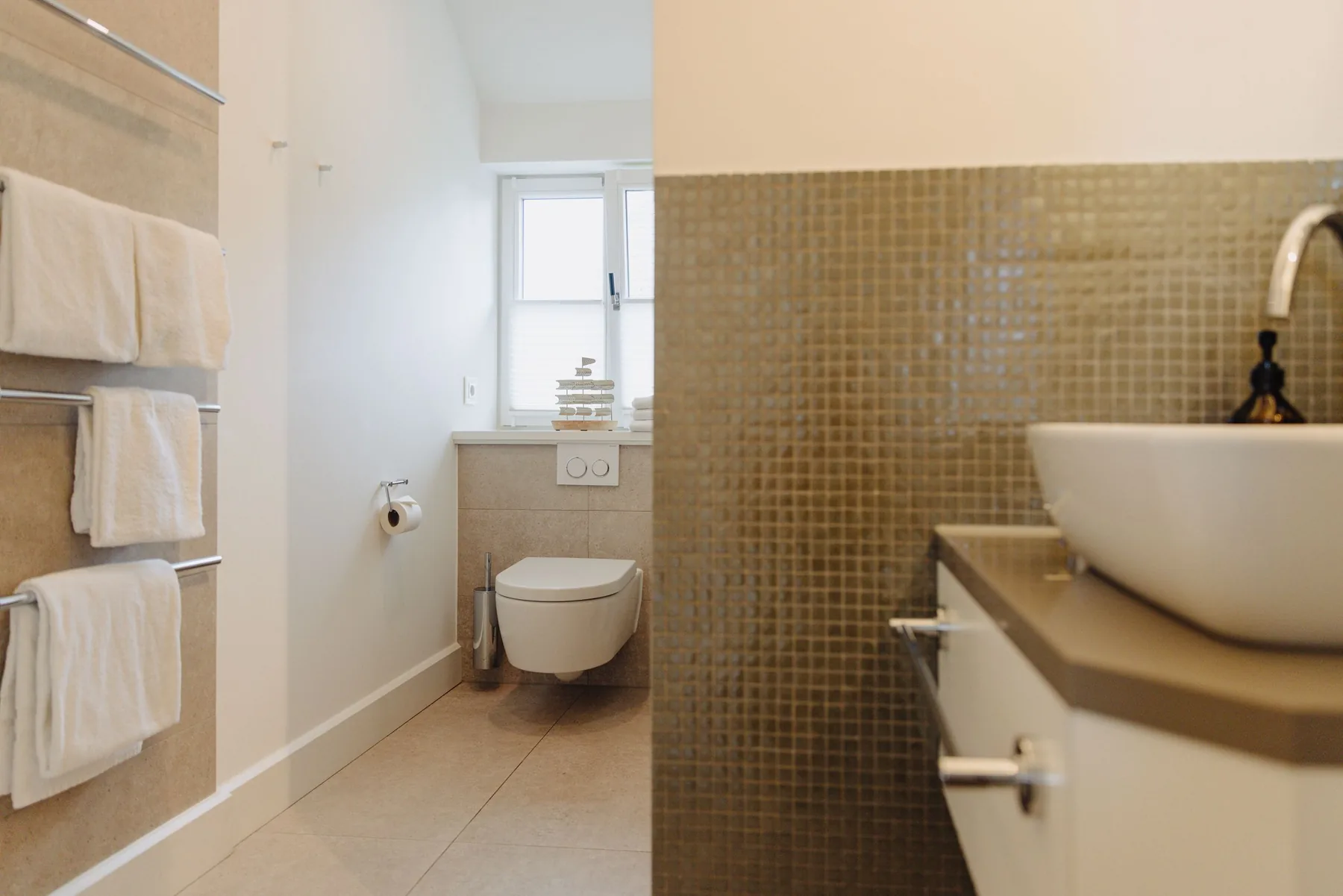 Ferienwohnung Wellenbrecher Sylt – Bad mit Goldmosaik und Aufsatzwaschbecken