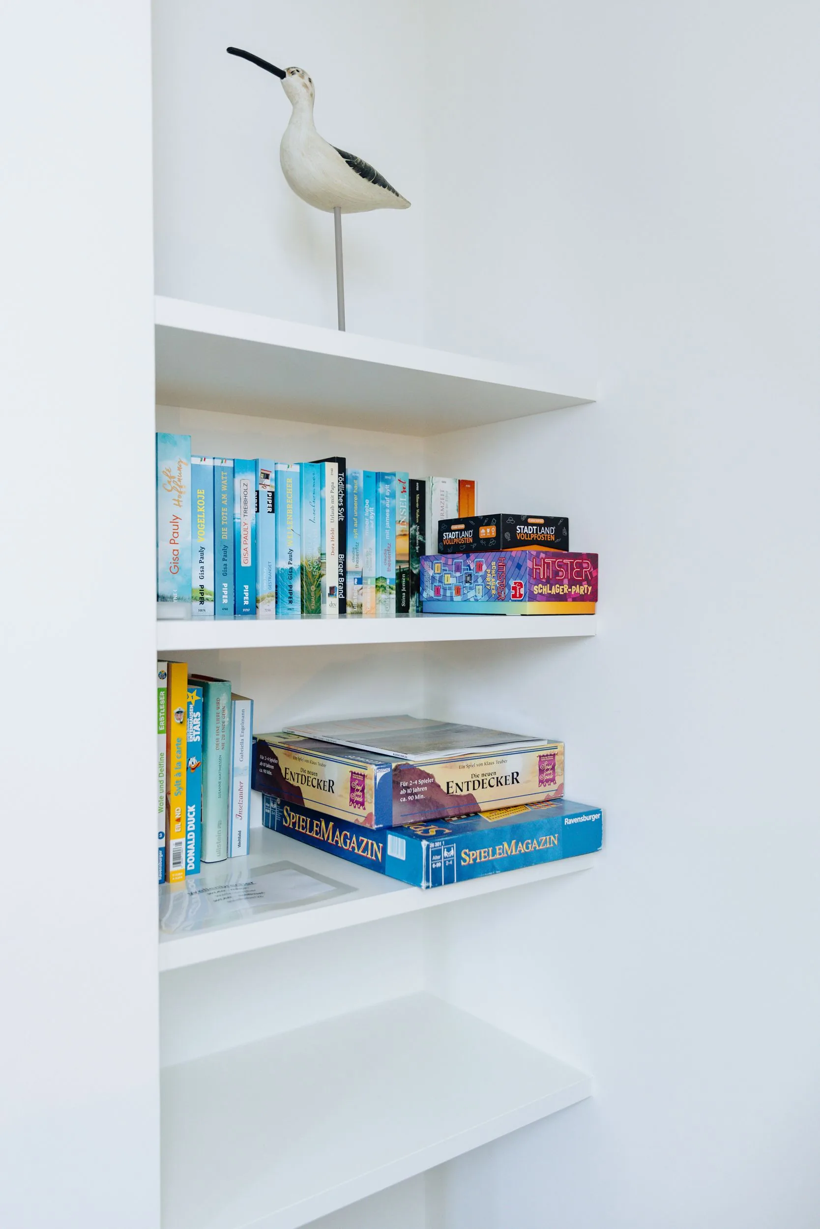 Ferienwohnung Wellenbrecher Sylt – Bücherregal mit Vogelfigur